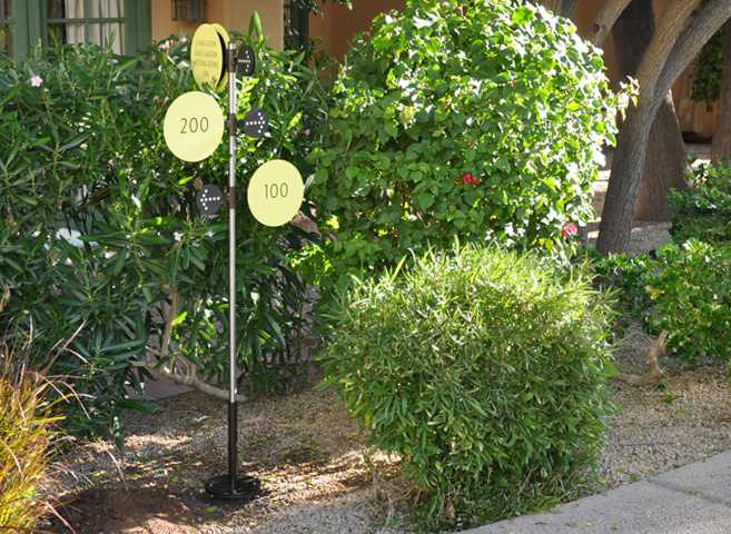 Exterior directional sign for courtyard. The sign panels focus on the simplicity of a pale yellow circle to keep with the simple and elemental theme of the property. The sign structures are brushed stainless tubes with machined and welded aluminum flanges and brackets. Assemblies held together with set screws for field adjustments. 